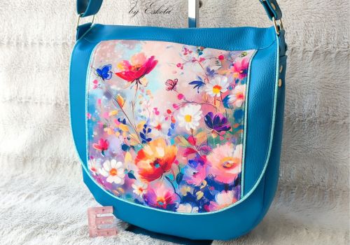 Sac besace Nira bleu avec motifs floraux.