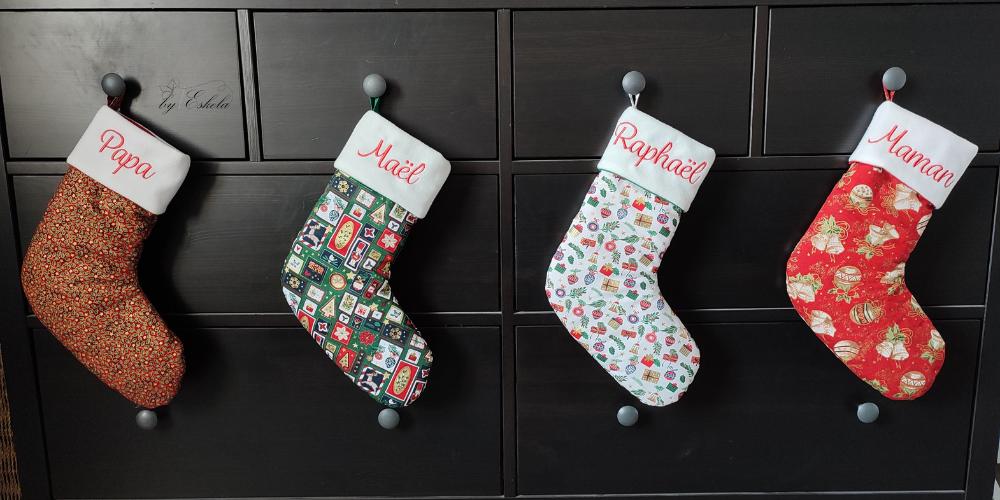 Plusieurs bottes de Noël avec différentes couleurs et les prénoms brodés.