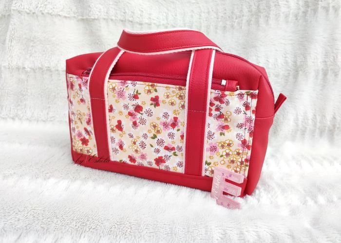 Trousse de toilette rouge avec des motifs de fleurs.